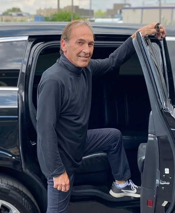 Club 390 Manager Dino posing outside of a limo.